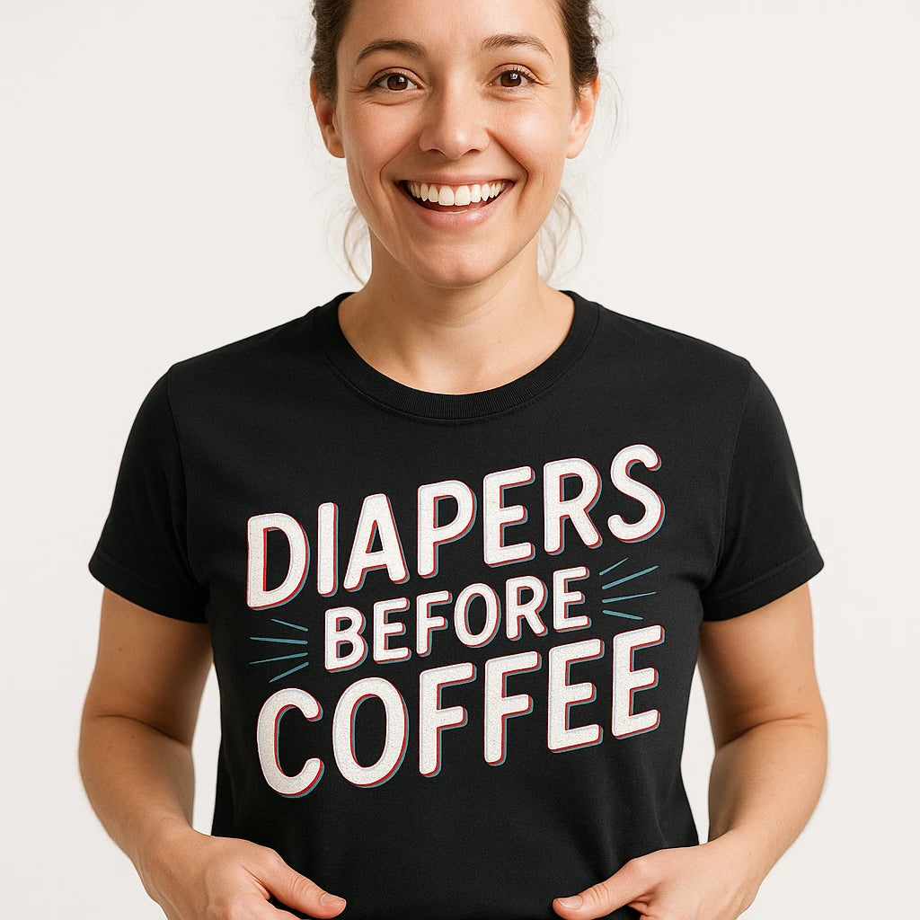 Close-up of the "Diapers Before Coffee" white print on a premium Bella+Canvas black new parents t shirt