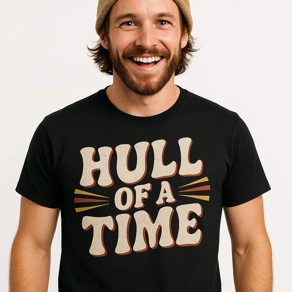 Close-up of the "Hull of a Time" beige print on a premium Bella+Canvas black boat neck t shirt
