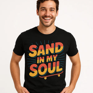 Close-up of the "Sand in My Soul" orange print on a premium Bella+Canvas black sandboarding t shirt