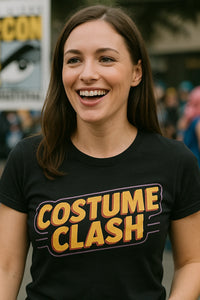 A person with long brown hair is smiling and wearing a black T-shirt with the words 