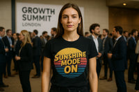 A person with long hair wearing a black T-shirt that reads 