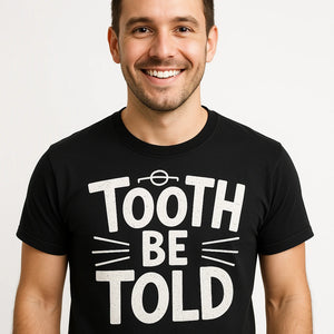 Close-up of the "Tooth Be Told" white print on a premium Bella+Canvas black dentist t shirt