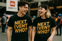 Two people are standing and laughing together. They are wearing matching black T-shirts with the text 