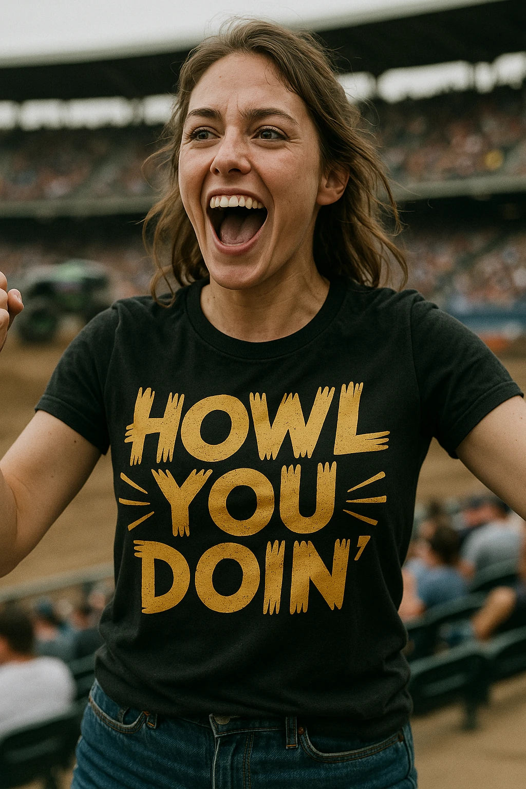 A person with long hair is energetically cheering, wearing a black T-shirt with bold yellow text. They are standing in a stadium with a blurred audience in the background.