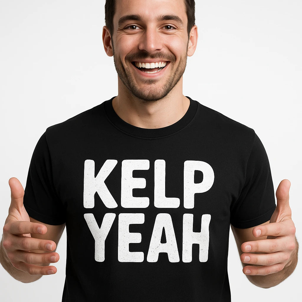 Close-up of the "Kelp Yeah" white print on a premium Bella+Canvas black sea otter shirts