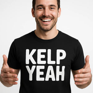 Close-up of the "Kelp Yeah" white print on a premium Bella+Canvas black sea otter shirts