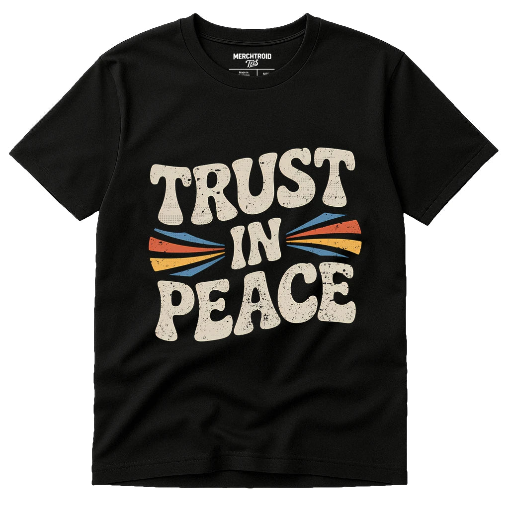 A black t-shirt with bold, retro-style text that reads "TRUST IN PEACE" in cream-colored letters. The design includes colorful arrows pointing inward toward the word "IN." The shirt has a round neckline and short sleeves.
