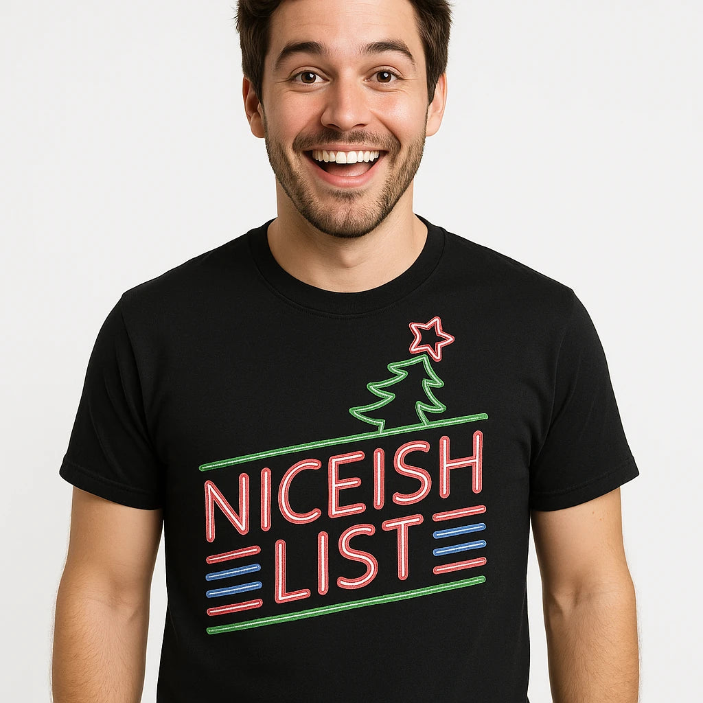 A person wearing a black t-shirt with neon-like text and graphics that reads "NICEISH LIST" along with a stylized Christmas tree and star. The person has short dark hair, a beard, and is smiling broadly. The background is plain white.