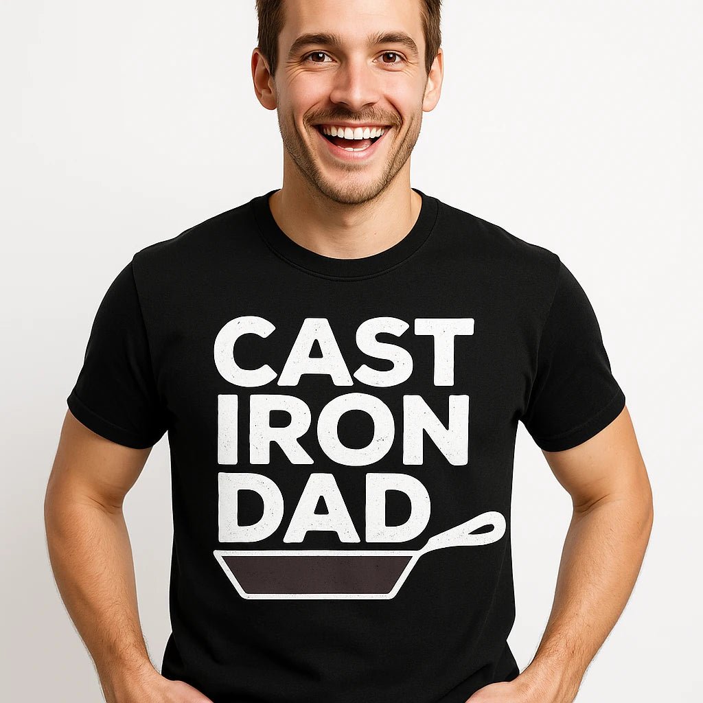 A person is wearing a black t-shirt with the text "CAST IRON DAD" and an illustration of a cast iron skillet. The person is smiling and has short hair.