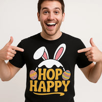 A cheerful person is pointing to their black shirt, which features bunny ears and colorful Easter eggs surrounding the text 