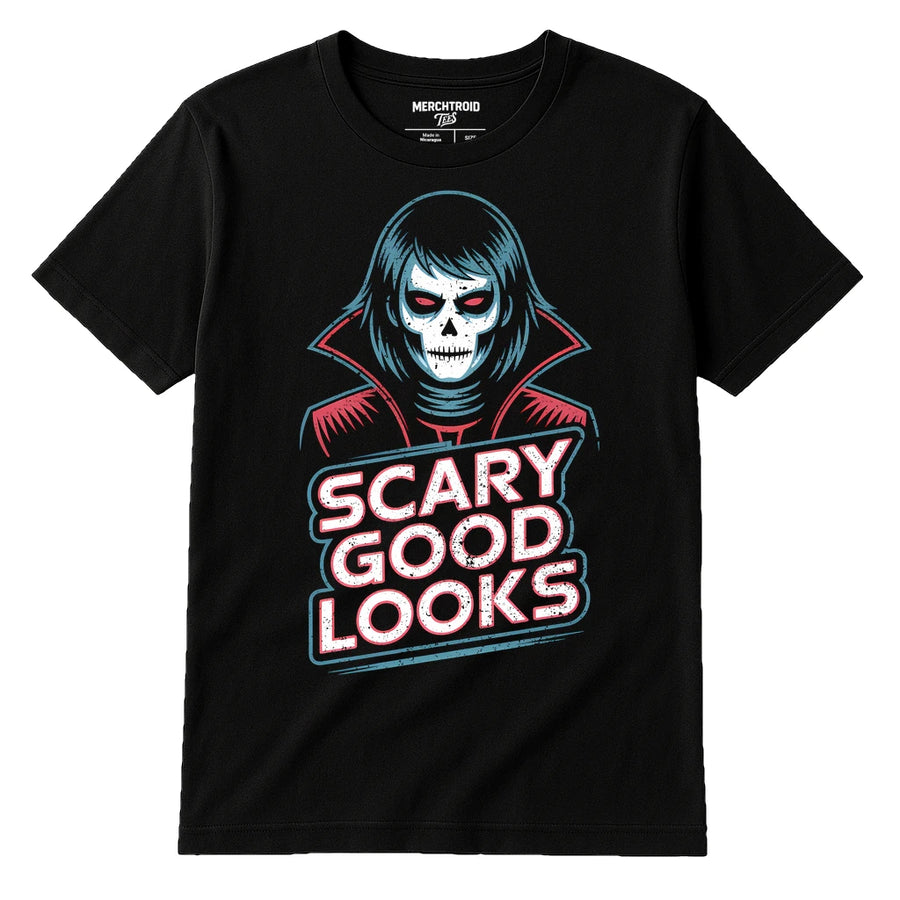 A black t-shirt featuring a graphic design of a stylized figure with pale skin and dark eyes, resembling a skull-faced vampire. The figure is wearing a high-collared red cloak. Below the figure, the text reads "SCARY GOOD LOOKS" in bold, distressed white and red letters. The tag at the neckline displays the brand "MERCHTROID".