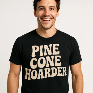 Close-up of the "Pine Cone Hoarder" beige print on a premium Bella+Canvas black nature walk shirts
