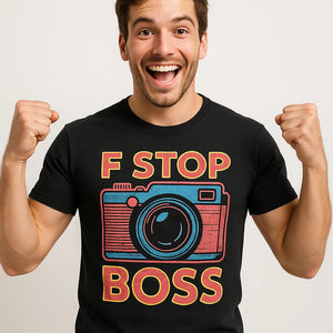 Close-up of the "F Stop Boss" orange print on a premium Bella+Canvas black photographers shirts