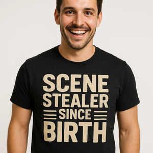 Close-up of the "Scene Stealer Since Birth" beige print on a premium Bella+Canvas black actor shirts