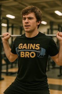 A person is in a gym setting, performing a squat while holding a barbell across their shoulders. They are wearing a black T-shirt with the text 