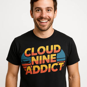 Close-up of the "Cloud Nine Addict" orange print on a premium Bella+Canvas black flying t shirt