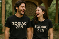 A man and woman are standing outdoors, both smiling widely. They are wearing matching black t-shirts with the text 