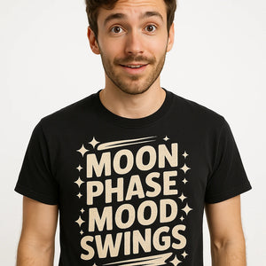 Close-up of the "Moon Phase Mood Swings" beige print on a premium Bella+Canvas black stargazing t shirt