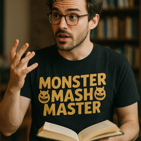 A person with glasses and facial hair is animatedly gesturing while holding an open book. They are wearing a black t-shirt with yellow text that says 