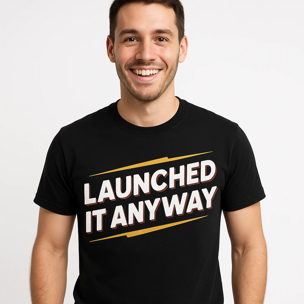 A person with short, dark hair smiling and wearing a black t-shirt with the text "LAUNCHED IT ANYWAY" in bold white and red letters. The background is plain white.