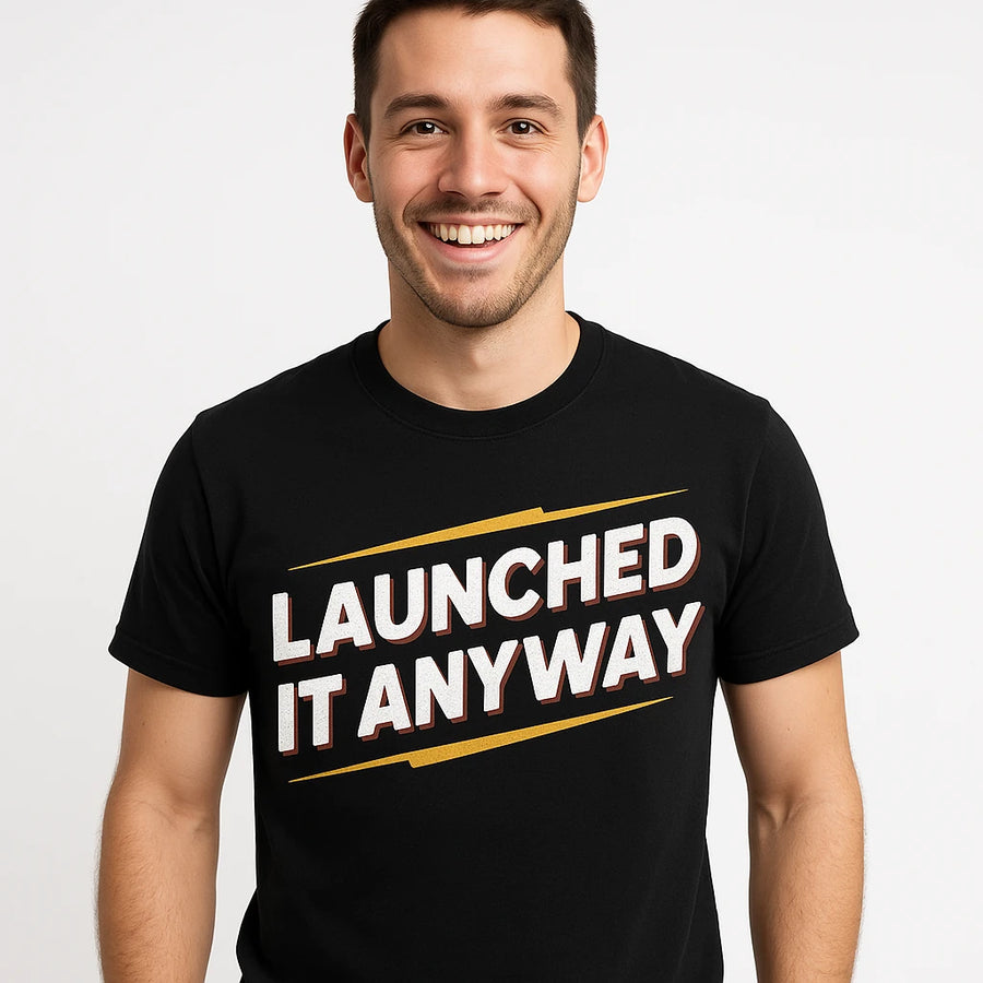 A person with short, dark hair smiling and wearing a black t-shirt with the text "LAUNCHED IT ANYWAY" in bold white and red letters. The background is plain white.
