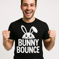 A person is smiling broadly and has hands clenched in excitement. They are wearing a black T-shirt featuring a graphic of a cute bunny above the text 
