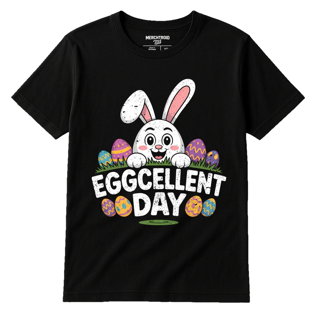 A black T-shirt featuring a cartoon bunny with large ears peeking from behind colorful Easter eggs. The text "EGGCELLENT DAY" is displayed below the bunny in bold, white letters. The shirt label reads "MERCHTROID."