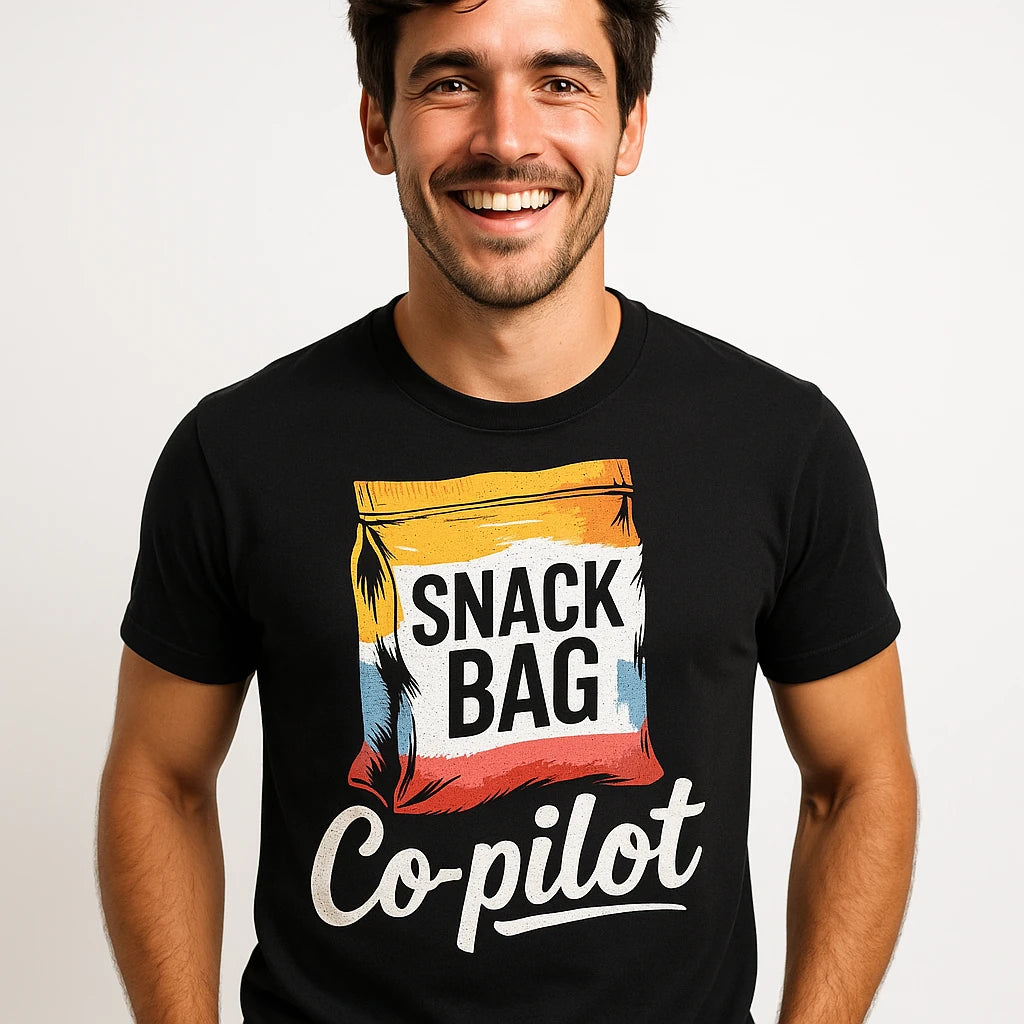 Close-up of the "Snack Bag Copilot" white print on a premium Bella+Canvas black road trip t shirt