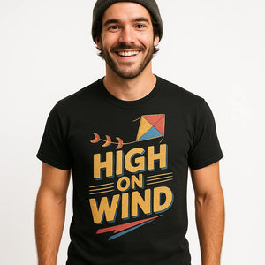 Close-up of the "High on Wind" gold print on a premium Bella+Canvas black kite flying t shirt