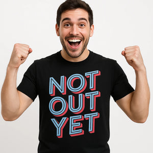 Close-up of the "Not Out Yet" light gray print on a premium Bella+Canvas black cricket shirts