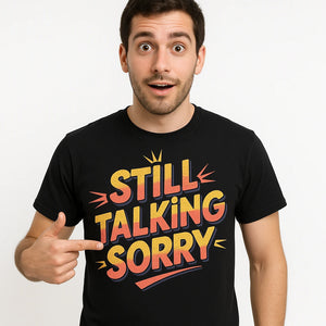 Close-up of the "Still Talking Sorry" orange print on a premium Bella+Canvas black personalized travel guide