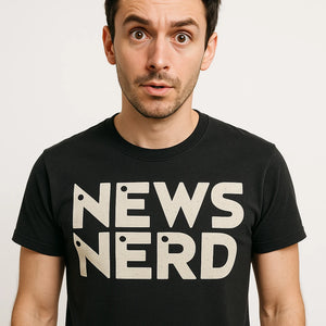 Close-up of the "News Nerd" beige print on a premium Bella+Canvas black journalist t shirt