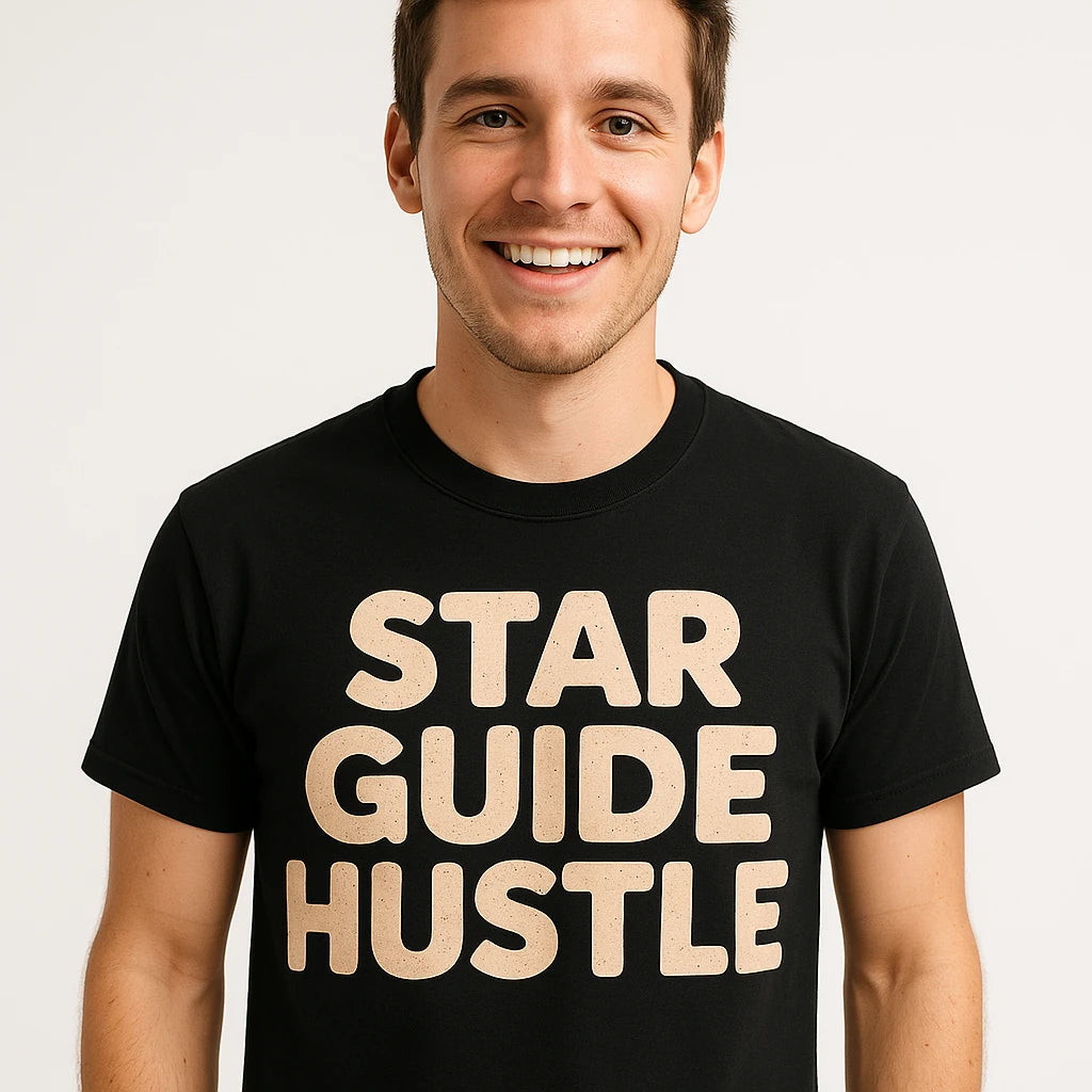 A person with short brown hair is smiling and wearing a black T-shirt with the text "STAR GUIDE HUSTLE" printed in large beige letters.