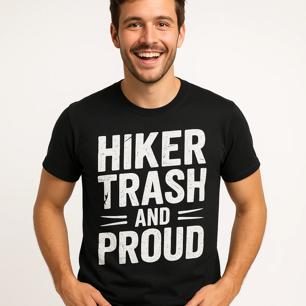 Close-up of the "Hiker Trash and Proud" white print on a premium Bella+Canvas black best backpacking shirts