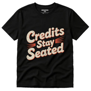 Black Graphic Tee - "Credits Stay Seated" graphic tee with beige print, flat lay product photo