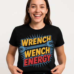 Close-up of the "Wrench Wench Energy" orange print on a premium Bella+Canvas black mechanic shirts