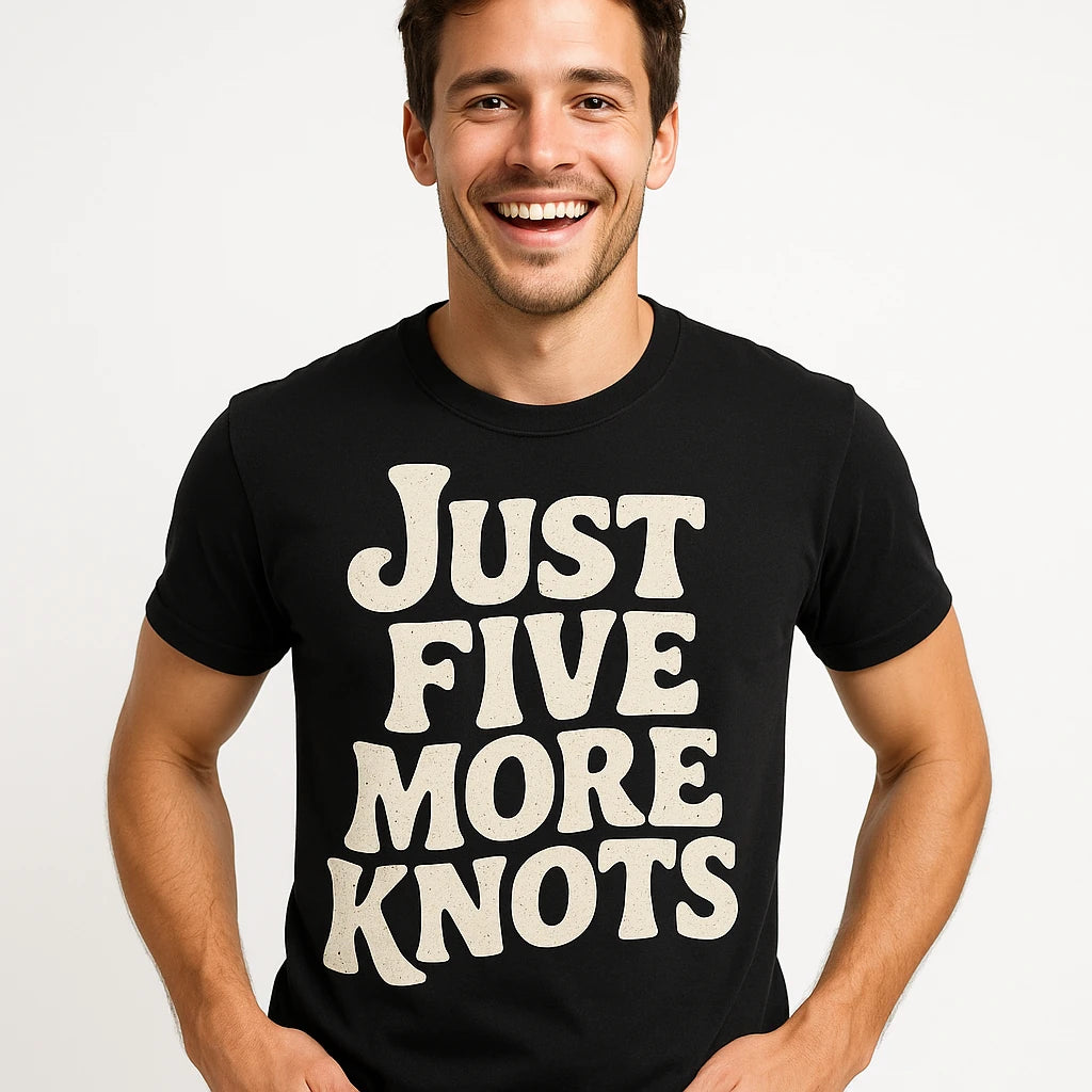 Close-up of the "Just Five More Knots" beige print on a premium Bella+Canvas black bushcraft t shirt