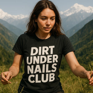 Lifestyle shot of the "Dirt Under Nails Club" black foraging t shirt in a real-world setting