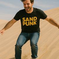 A person with short dark hair, wearing a black T-shirt with the words 