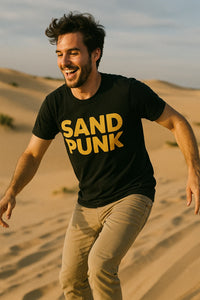 A man with dark hair and a beard is wearing a black T-shirt with the words 