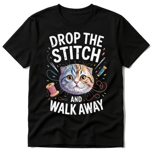 Black T Shirt Sewing Pattern - "Drop the Stitch and Walk Away" graphic tee with white print, flat lay product photo