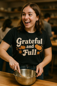 A person with shoulder-length brown hair, wearing a black shirt that reads 