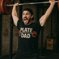 A person is lifting a barbell with red weight plates while wearing a black T-shirt with the text 