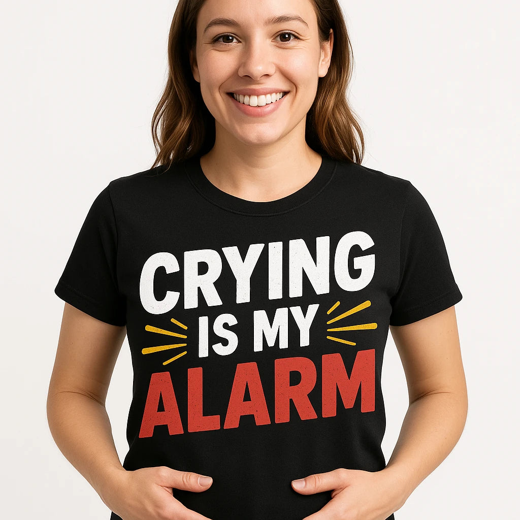 Close-up of the "Crying Is My Alarm" white print on a premium Bella+Canvas black first time parents t shirts