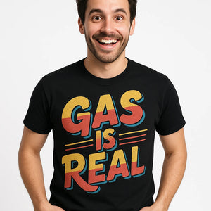 Close-up of the "Gas Is Real" orange print on a premium Bella+Canvas black musician t shirt