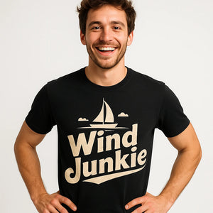 Close-up of the "Wind Junkie" cream print on a premium Bella+Canvas black sailing t shirt
