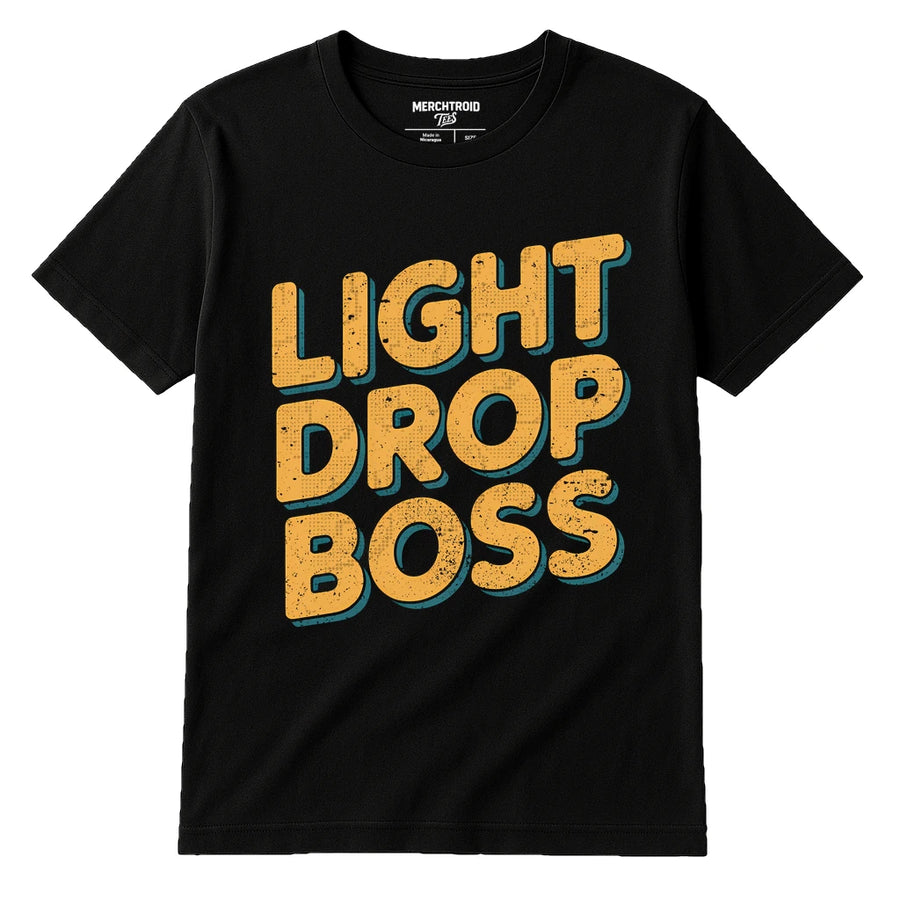 A black T-shirt with bold, textured yellow text in a stacked format. The words "LIGHT DROP BOSS" are prominently displayed on the front. The design has a vintage, distressed look. The brand label "MERCHTROID" is visible inside the collar.