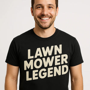 Close-up of the "Lawn Mower Legend" beige print on a premium Bella+Canvas black dad tee