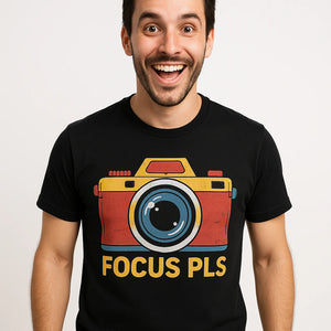 Close-up of the "Focus Pls" orange print on a premium Bella+Canvas black custom t shirts for photographers