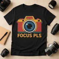 A black t-shirt featuring a colorful illustration of a camera with the text 